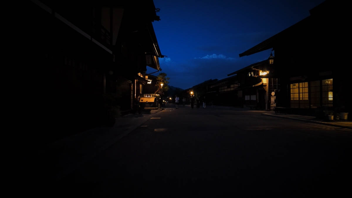 格子の窓の明かりと、奥の人影