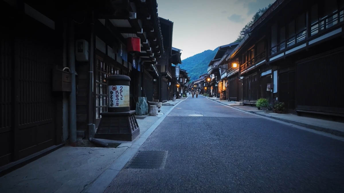 漆器店の看板と、奥へ続く格子の通り