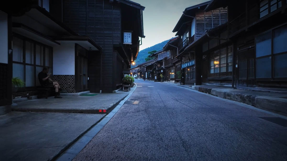 ベンチに座る人と、曲がり角の通り
