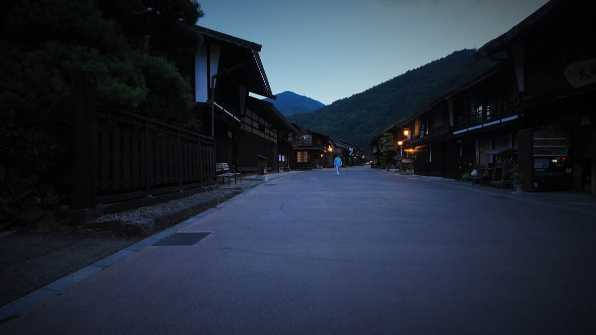 一人が歩く通りと、遠くの山