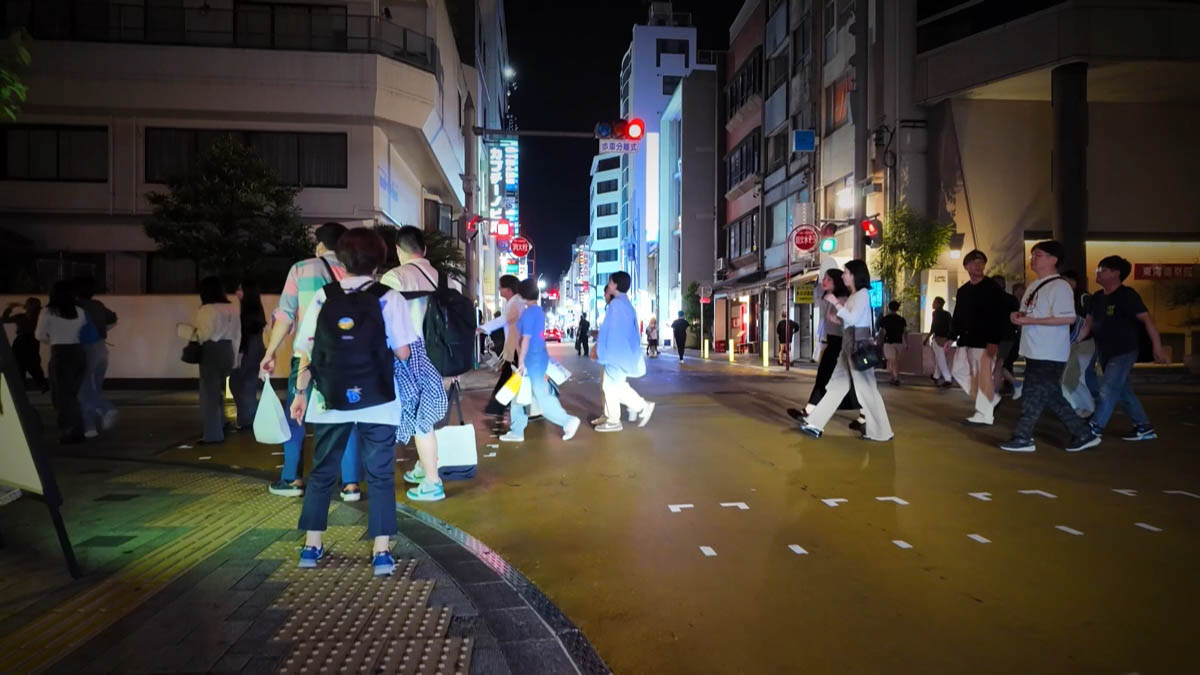 駅前の交差点 横断歩道を渡る人たちと、赤い信号